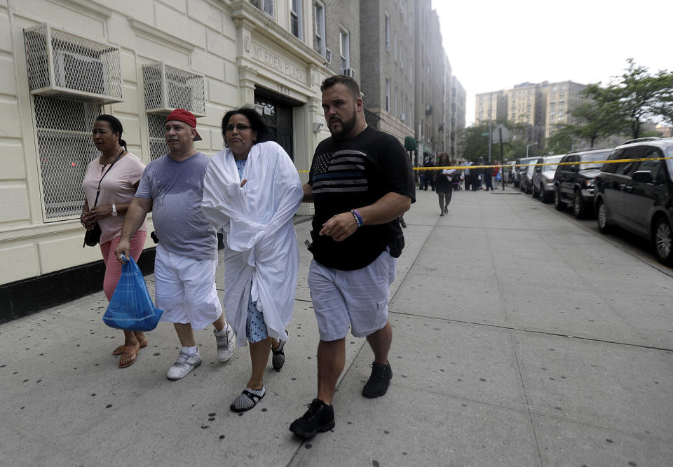 <p>A woman is escorted by officers in plainclothes near the Bronx Lebanon Hospital in New York after a gunman opened fire there on Friday, June 30, 2017. (AP Photo/Julio Cortez) </p>