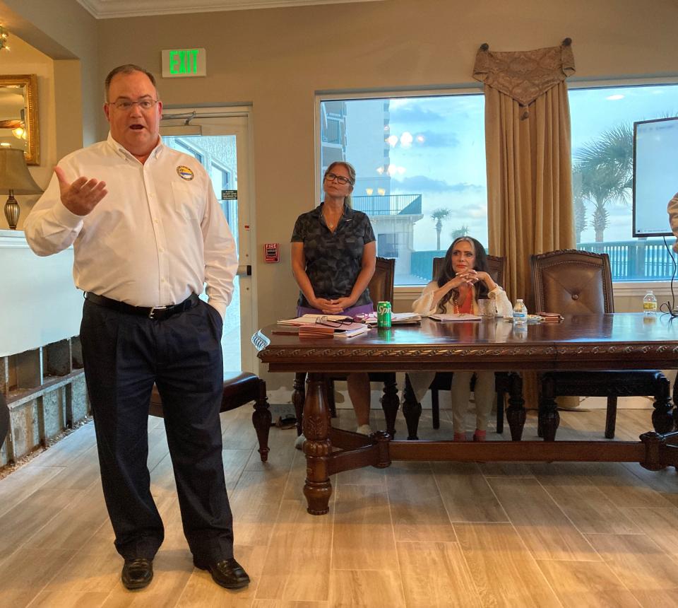 Daytona Beach Shores City Manager Kurt Swartzlander speaks to a crowd on Monday at the south tower of Dimucci Twin Towers, as Dimucci condo association president Robin White, middle, and Dimucci board member Lesley Vogel watch.
(Photo: SHELDON GARDNER)