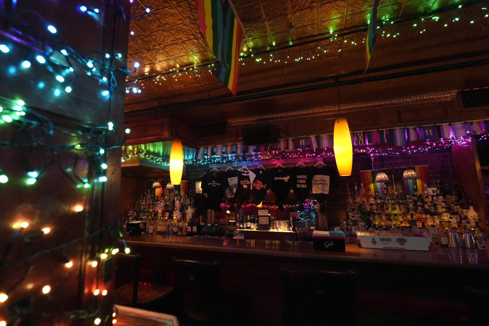 Festive lights and flags adorn the bar inside the Stonewall Inn, Monday, June 17, 2024, in New York. The space next door to the bar will open as the new visitor center for the Stonewall National Monument on the anniversary of the 1969 rebellion that helped reshape LGBTQ+ life in the United States. (AP Photo/Pamela Smith)