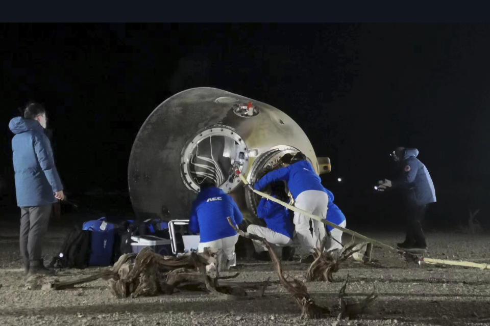 In this photo released by Xinhua News Agency, ground crew check on the astronauts inside the re-entry capsule of the Shenzhou-14 manned space mission after it lands successfully at the Dongfeng landing site in northern China's Inner Mongolia Autonomous Region, Sunday, Dec. 4, 2022. Three Chinese astronauts landed in a northern desert on Sunday after six months working to complete construction of the Tiangong station, a symbol of the country's ambitious space program, state TV reported. (Li Gang/Xinhua via AP)