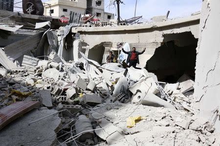 A man reacts as he stands on debris from his collapsed home after what activists said were air strikes by forces loyal to Syria's President Bashar al-Assad in Marj Al Sultan, in the eastern Damascus suburb of Ghouta February 27, 2015. REUTERS/Amer Almohibany