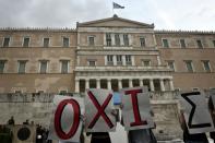 Leftist youth hold placards reading 'no' in front of the Greek parliament , during a demonstration calling for a 'NO' at a referendum and for Greece's exit from the eurozone on June 28, 2015