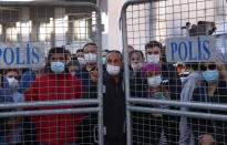 Local residents watch as medics and rescue personnel carry into an ambulance an injured person from the debris of a collapsed building in Izmir, Turkey, Saturday, Oct. 31, 2020. Rescue teams on Saturday ploughed through concrete blocs and debris of eight collapsed buildings in Turkey's third largest city in search of survivors of a powerful earthquake that struck Turkey's Aegean coast and north of the Greek island of Samos, killing dozens Hundreds of others were injured. (AP Photo/Darko Bandic)