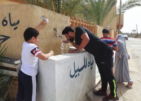 People drink water during a water shortage in Tripoli
