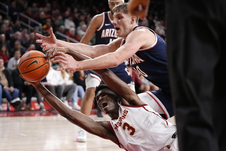 Southern California forward VIncent Iwuchukwu, below, and Arizona forward Azuolas Tubelis reach for a loose ball during the second half of an NCAA college basketball game Thursday, March 2, 2023, in Los Angeles. (AP Photo/Mark J. Terrill)