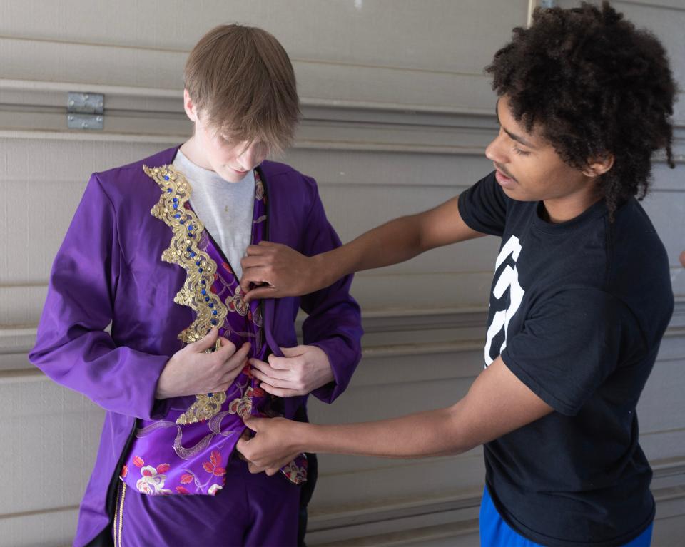 Recent Tuslaw graduate Randolph McFarren fits a costume for actor Lucas Davis during a rehearsal of a musical based off the Jane Austen book "Mansfield Park" in his family garage in Lawrence Township. McFarren hand sewed all of the costumes for the musical.
