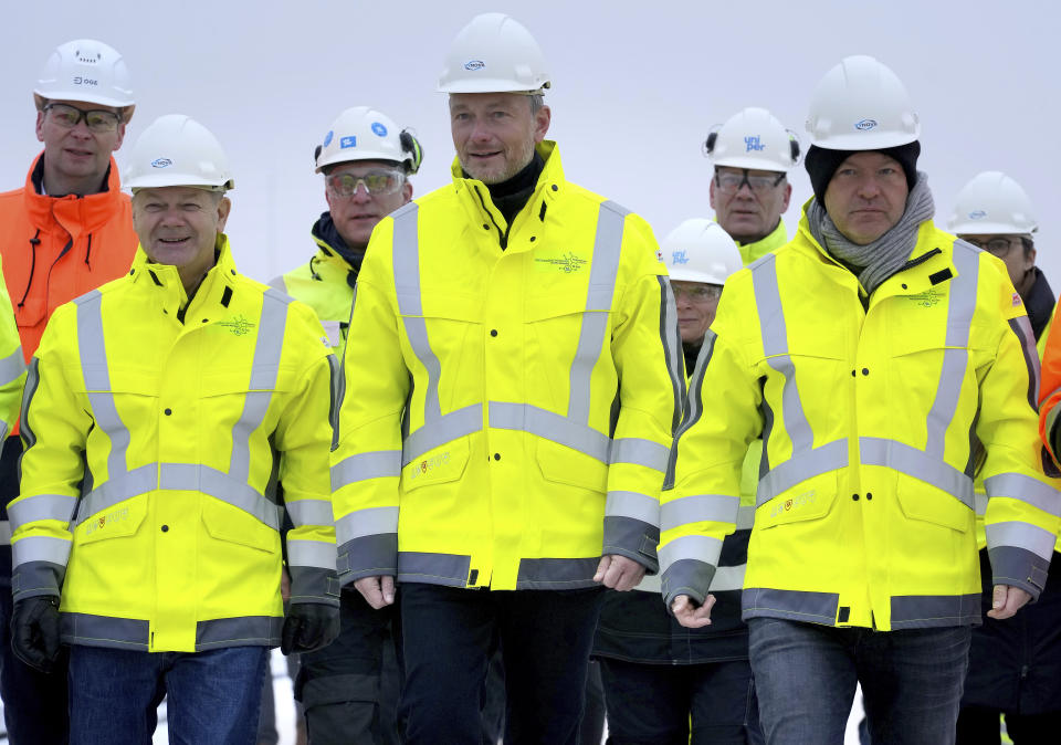 Front from left, German Chancellor Olaf Scholz, German Finance Minister Christian Lindner and German Economy and Climate Minister Robert Habeck arrive for a visit at the 'Hoegh Esperanza' Floating Storage and Regasification Unit (FSRU) during the opening of the LNG (Liquefied Natural Gas) terminal in Wilhelmshaven, Germany, Saturday, Dec. 17, 2022. (AP Photo/Michael Sohn, pool)