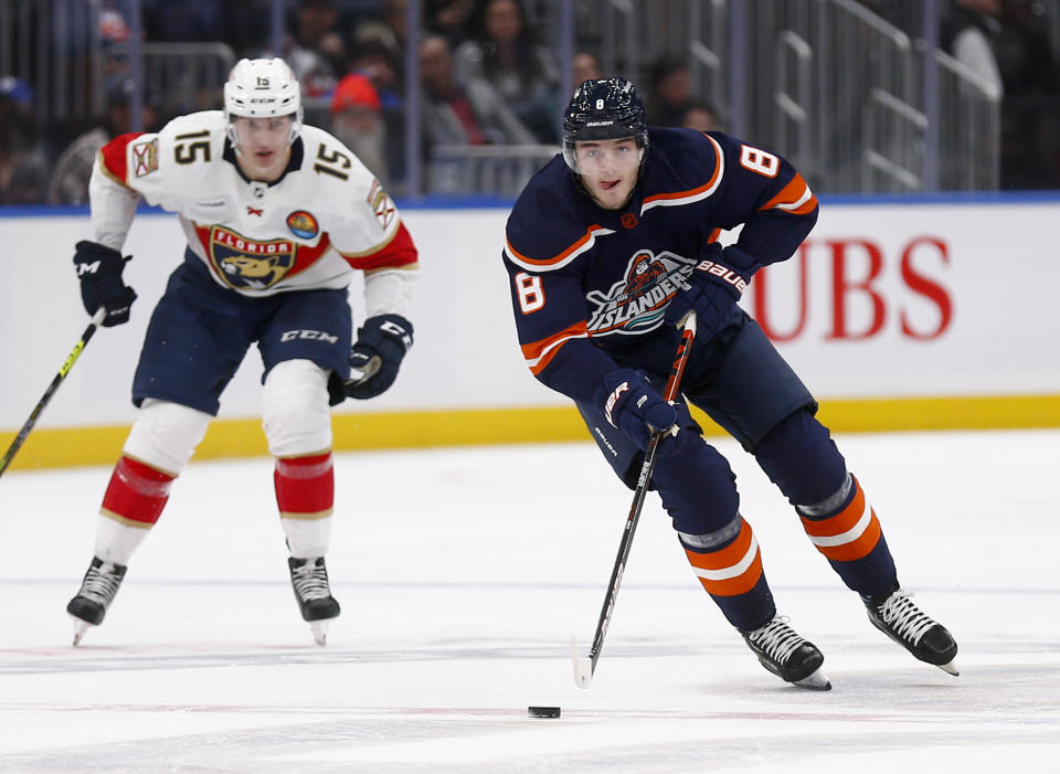 New York Islanders defenseman Noah Dobson (8) skates up the ice trailed by Florida Panthers center Anton Lundell (15) during the second period of an NHL hockey game Friday, Dec. 23, 2022, in Elmont, N.Y. (AP Photo/John Munson)