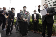 Plaintiffs and their supporters gather to walk toward the Tokyo District Court Thursday, Oct. 14, 2021, in Tokyo. The court is hearing five ethnic Korean residents of Japan and a Japanese national demanding the North Korean government pay compensation over their human rights abuses in that country after joining a resettlement program there that promised a “paradise on Earth,” but without the presence of a defendant - the North’s leader. (AP Photo/Eugene Hoshiko)