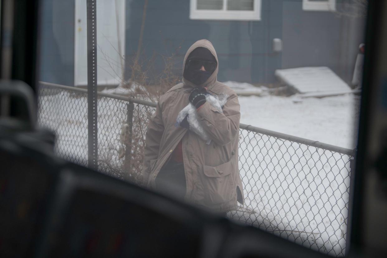 A woman waits at a bus stop along the Highland Park route in Pueblo on Thursday, March 16, 2023.