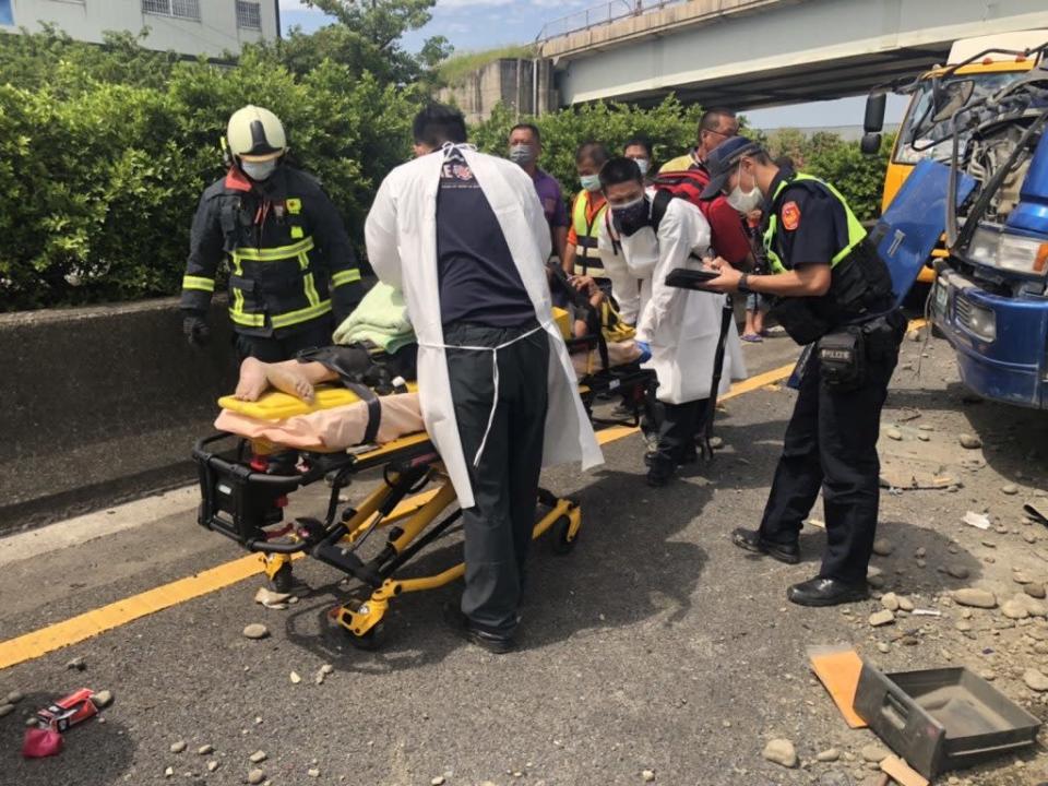 國道一號北上神岡區路段，一輛砂石車側翻，駕駛受傷，消防人員搶救送醫。（記者徐義雄翻攝）