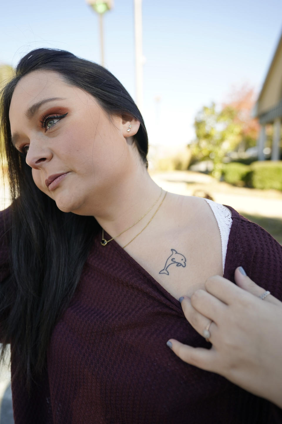 Lindsey Kirk shows a tattoo on her neck that commemorates her late mother's favorite animal, a dolphin, on Saturday, Nov. 13, 2021, in New Albany, Miss. She was 12 years old when her stepfather, David Neal Cox, terrorized her family, sexually assaulted her, and killed her mother, Kim Kirk Cox, in May 2010 at a home in Sherman, Miss. The Mississippi Supreme Court set an execution date of Wednesday, Nov. 17, 2021, for Cox after he said he wanted to surrender all appeals. (AP Photo/Rogelio V. Solis)