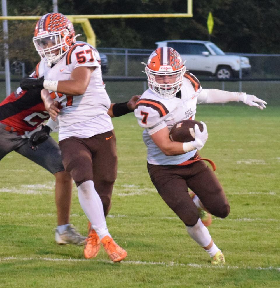 Heath's Connor Corbett cuts past the block of teammate J.J. Holloway during the Bulldogs' 21-14 victory at Utica on Friday.