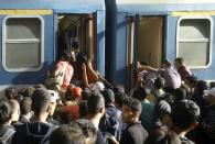 Migrants board a train heading to the Hungarian-Austrian border at the main Keleti train station in Budapest on September 3, 2015, after authorities re-opened the station