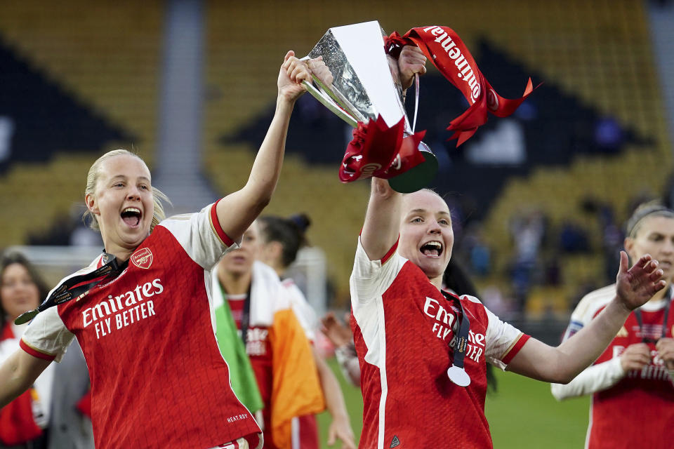Arsenal's Beth Mead, left, and Kim Little, right, lift the trophy after winning the FA Women's Continental Tyres League Cup Final soccer match between Arsenal and Chelsea at Molineux Stadium, Wolverhampton, England, Sunday March 31, 2024. (David Davies/PA via AP)