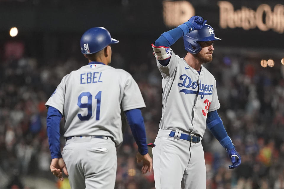 Los Angeles Dodgers' Cody Bellinger, right, gestures after hitting an RBI triple next to third base coach Dino Ebel (91) during the eighth inning of a baseball game against the San Francisco Giants in San Francisco, Tuesday, Aug. 2, 2022. (AP Photo/Jeff Chiu)