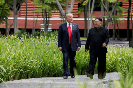 U.S. President Donald Trump and North Korea's leader Kim Jong Un walk together before their working lunch during their summit at the Capella Hotel on the resort island of Sentosa, Singapore June 12, 2018. Picture taken June 12, 2018. REUTERS/Jonathan Ernst/Files