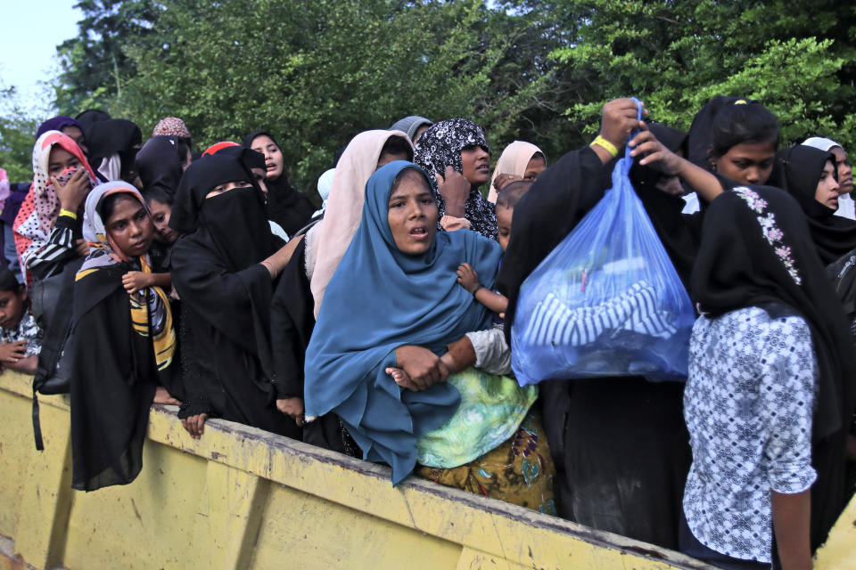 Ethnic Rohingya women and children board a truck as they are being relocated from their temporary shelter at the basement of a community hall following a protest rejecting Rohingya refugees in Banda Aceh, Aceh province, Indonesia, Wednesday, Dec. 27, 2023. Students in Indonesia's Aceh province rallied on Wednesday demanding the government drive away Rohingya refugees arriving by boat in growing numbers as police named more suspects of human trafficking. (AP Photo/Reza Saifullah)