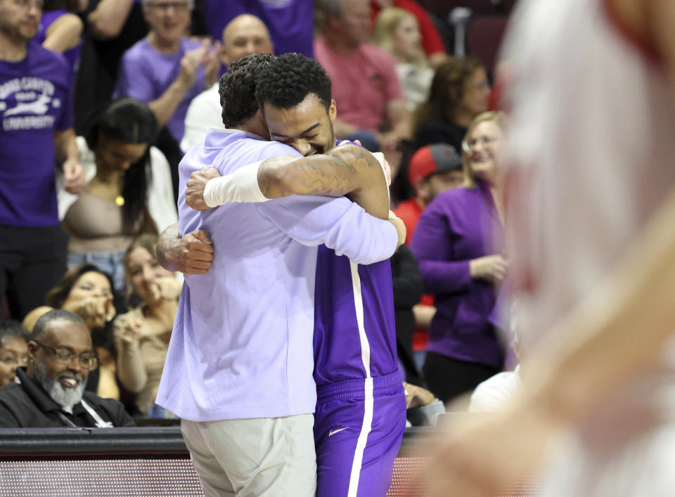 Grand Canyon guard Rayshon Harrison (0) embraces head coach Bryce Drew during the final moments of the second half of an NCAA college basketball game against Southern Utah in the championship of the Western Athletic Conference tournament Saturday, March 11, 2023, in Las Vegas. (AP Photo/Ronda Churchill)