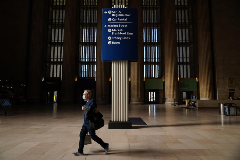 A traveler walks through the 30th Street Station ahead of the Thanksgiving holiday, Friday, Nov. 20, 2020, in Philadelphia. With the coronavirus surging out of control, the nation's top public health agency pleaded with Americans not to travel for Thanksgiving and not to spend the holiday with people from outside their household. (AP Photo/Matt Slocum)