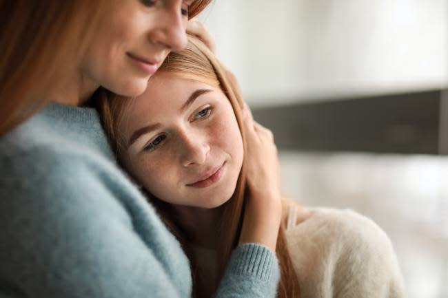 Madre abrazando a su hija adolescente