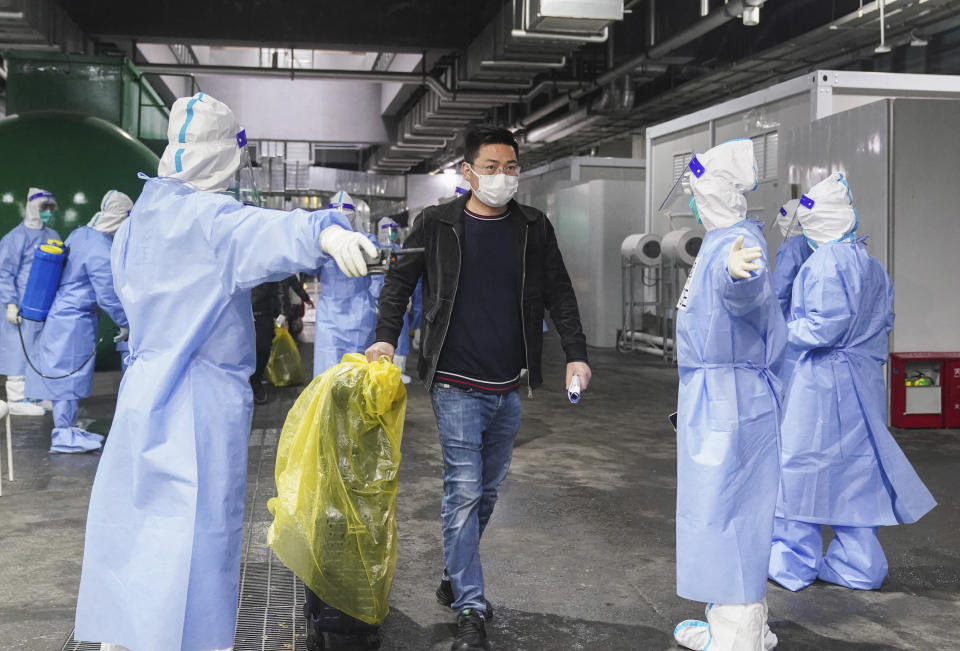 In this photo released by China's Xinhua News Agency, COVID-19 patients leave a makeshift hospital at the National Exhibition and Convention Center in Shanghai, Thursday, April 14, 2022. Anti-virus controls that shut down some of China's biggest cities and fueled public irritation are spreading as infections rise, hurting a weak economy and prompting warnings of possible global shockwaves. (Ding Ting/Xinhua via AP)