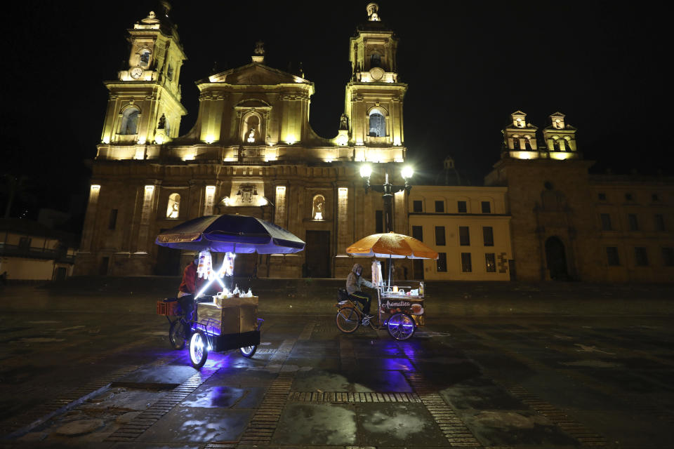 Street vendors leave Bolivar Square at the start of an official continuous multi-day curfew in an effort to contain the spread of new coronavirus infections, in Bogota, Colombia, Friday, Jan. 22, 2021. Colombia's capital city is reimposing lockdown measures as COVID-19 infections rise around the country. (AP Photo/Fernando Vergara)