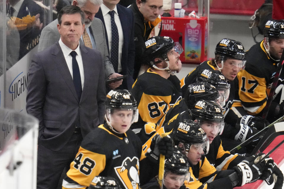 Pittsburgh Penguins head coach Mike Sullivan, left, stands behind his bench during the first period of an NHL hockey game against the New York Islanders in Pittsburgh, Tuesday, Feb. 20, 2024. (AP Photo/Gene J. Puskar)