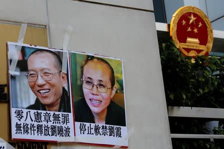Photos of Chinese Nobel rights activist Liu Xiaobo (L) and wife Liu Xia are left by protesters outside China's Liaison Office in Hong Kong, China June 27, 2017. REUTERS/Bobby Yip