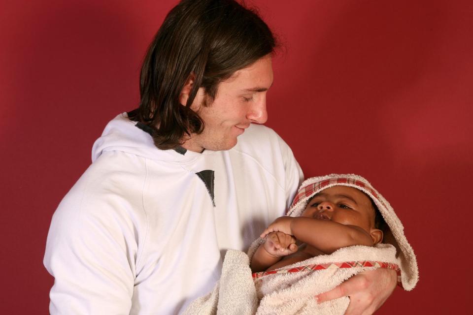 <p>Joan Monfort/AP</p> Lionel Messi holding Lamine Yamal in 2007