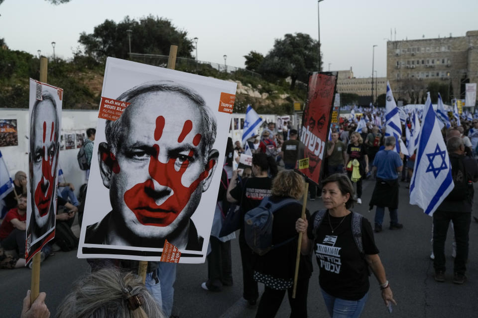 People take part in a protest against Israeli Prime Minister Benjamin Netanyahu's government and call for the release of hostages held in the Gaza Strip by the Hamas militant group outside of the Knesset, Israel's parliament, in Jerusalem, Sunday, March 31, 2024. (AP Photo/Leo Correa)