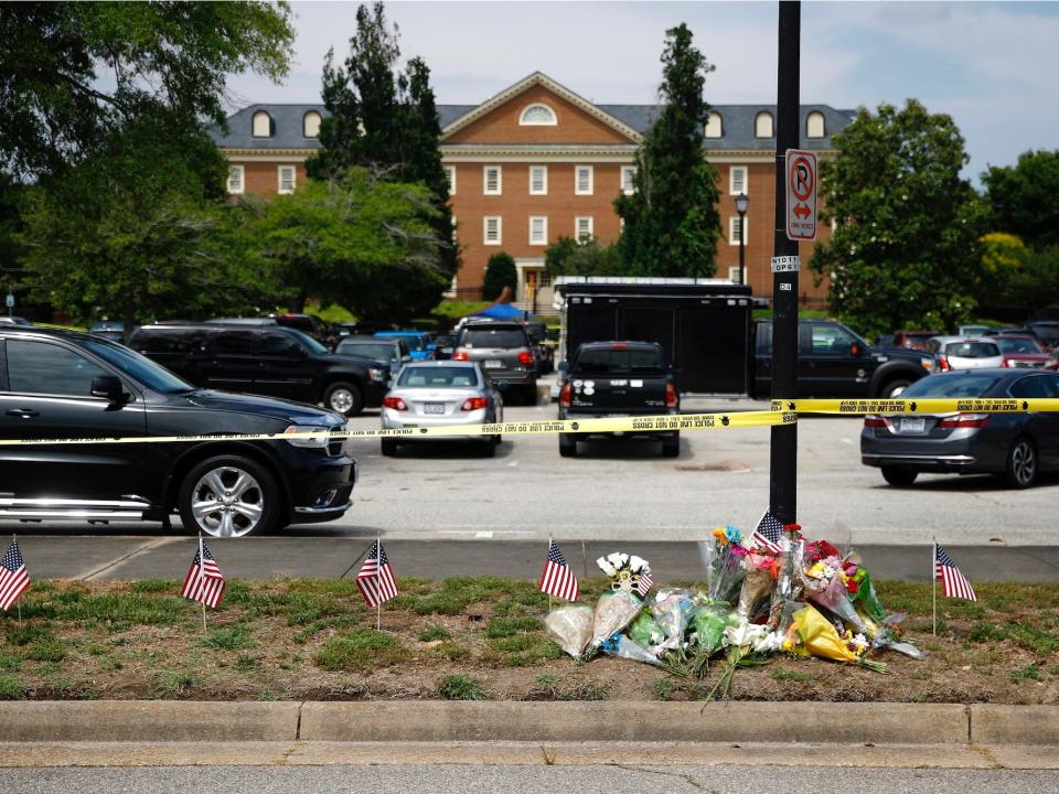 A makeshift memorial rests at the edge of a police cordon in front of a municipal building that was the scene of a shooting