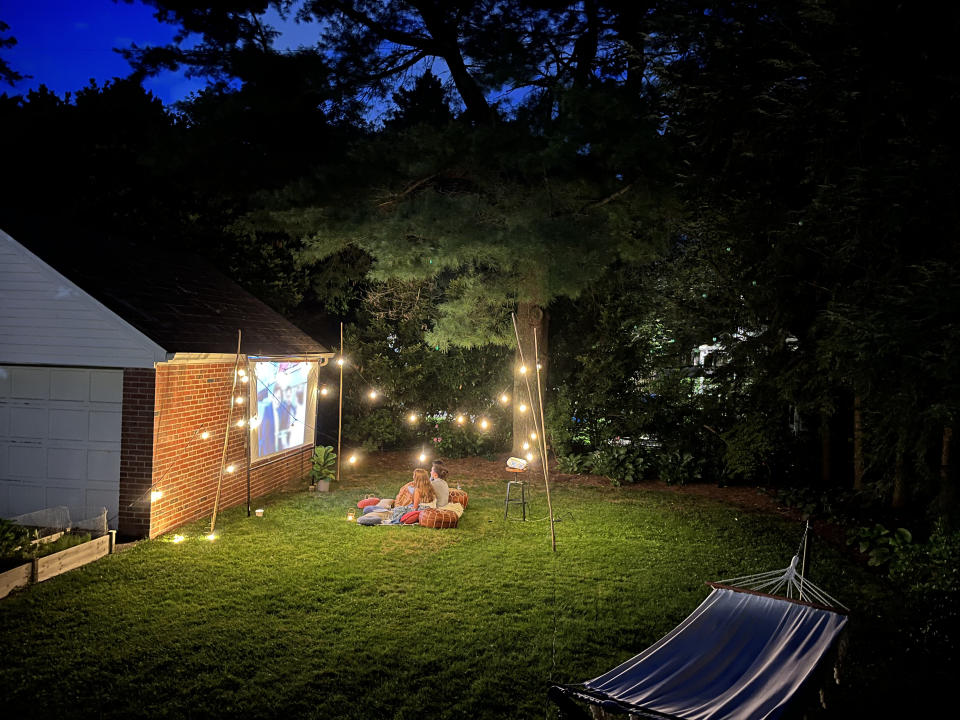 kids watching a movie in their backyard