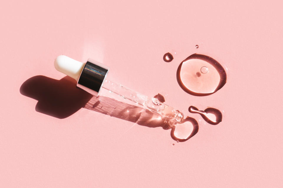 Serum droplet and drops against pink background