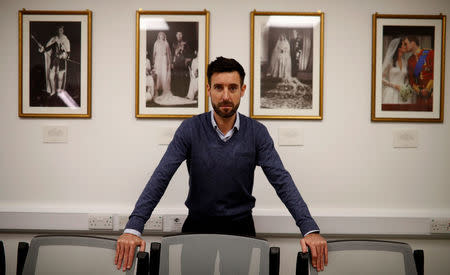 Ben Roberts, Managing Director of Clogau, poses in front of photographs of the British royal family at their office in Bodelwyddan, North Wales, Britain, March 12, 2018. Picture taken March 12, 2018. REUTERS/Phil Noble