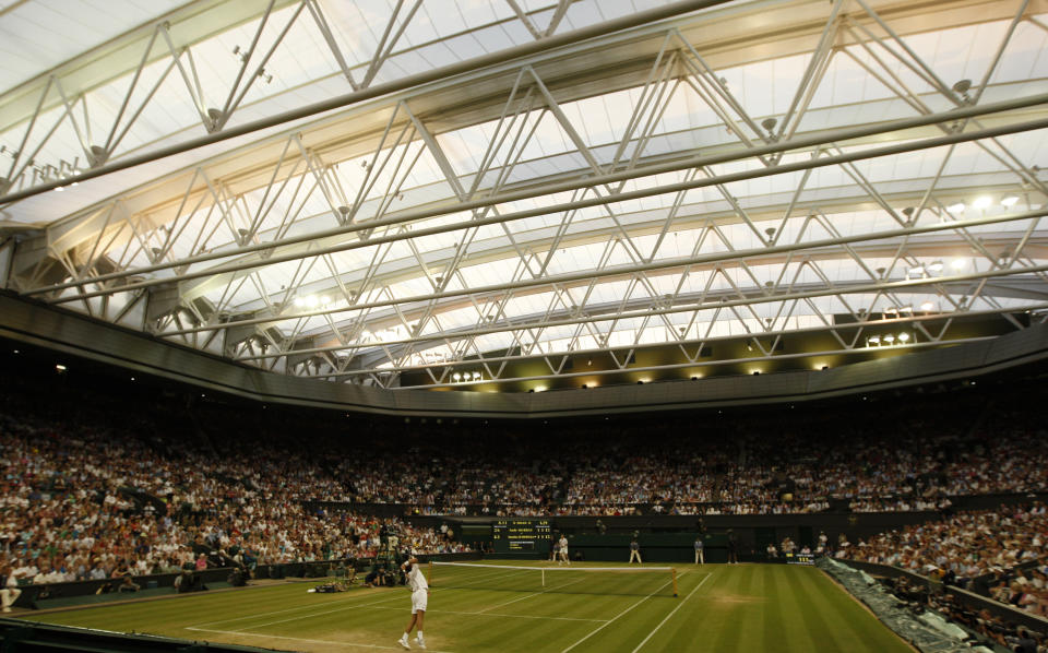 FILE - Stanislas Wawrinka, of Switzerland, foreground, serves to Andy Murray, of Britain, during their fourth round singles match at Wimbledon, in this Monday, June 29, 2009, file photo. How much do you know about Wimbledon? (AP Photo/Alastair Grant, File)