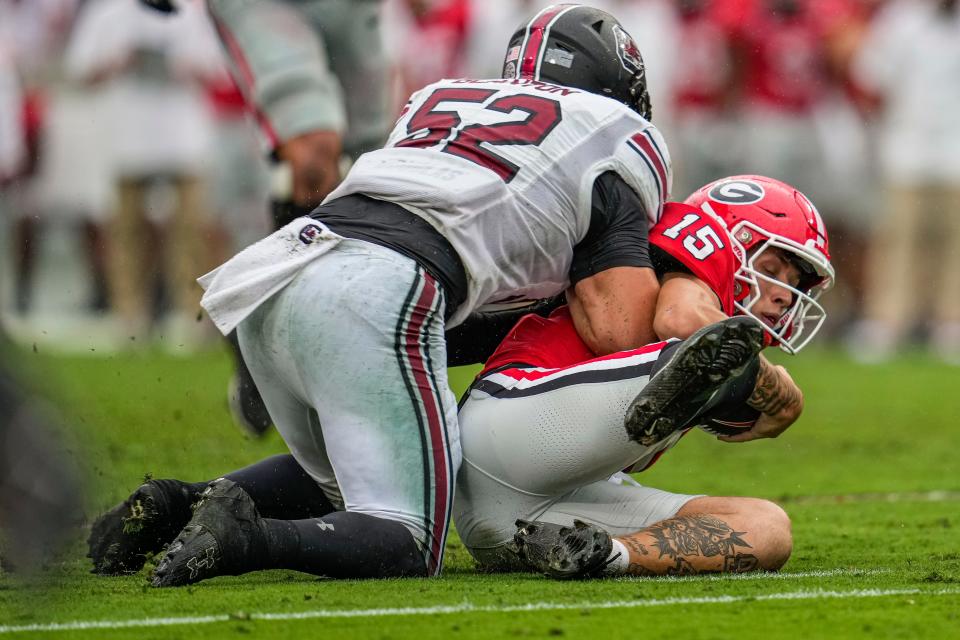 Georgia's Carson Beck is hit late by South Carolina linebacker Stone Blanton.