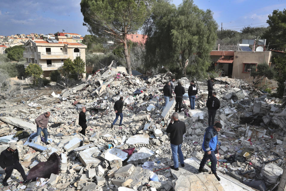 Lebanese citizens gather on the rubles of a house that was destroyed by an Israeli airstrike Tuesday night, in Bint Jbeil, South Lebanon, Wednesday, Dec. 27, 2023. One Hezbollah fighter and two civilians, a newlywed couple, were killed in an overnight Israeli strike on a family-owned residential building in the town of Bint Jbeil, local residents and state media said Wednesday. (AP Photo/Mohammed Zaatari)