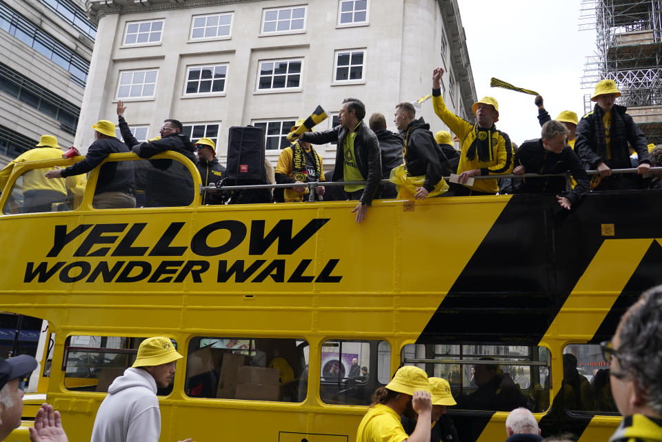 Dortmund supporters react as they ride in an open-top bus near Piccadilly Circus in central London ahead of the Champions League final soccer match between Borussia Dortmund and Real Madrid which will take place at Wembley stadium later, Saturday, June 1, 2024. (AP Photo/Alberto Pezzali)