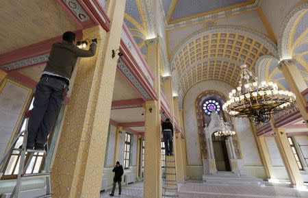 Workers put the final touches during the restoration of the Great Synagogue in Edirne, western Turkey, February 26, 2015. When the domes of Edirne's abandoned Great Synagogue caved in, Rifat Mitrani, the town's last Jew, knew it spelled the end of nearly two millennia of Jewish heritage in this Turkish town. As a boy, Mitrani studied Hebrew in the synagogue's gardens and, in the 1970s, dispatched its Torah to Istanbul after the community shrank to just three families. In 1975, he unlocked its doors and swept away the cobwebs to marry his wife Sara. Now a five-year, $2.5 million government project has restored the synagogue's lead-clad domes and resplendent interior ahead of its Thursday re-opening, the first temple to open in Turkey in two generations, but one without worshippers. It is part of a relaxation of curbs on religious minorities ushered in during President Tayyip Erdogan's 12 years in power. Yet it coincides with a spike in anti-Semitism in predominantly Muslim Turkey and a wave of Jews moving away, say members of the aging community, which has shrunk by more than a third in the last quarter century. Picture taken February 26, 2015. REUTERS/Murad Sezer
