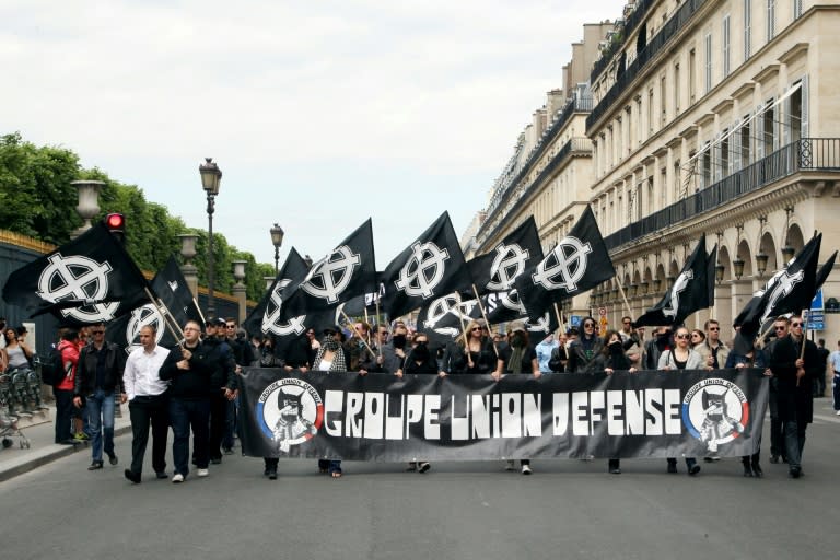 Des membres du syndicat étudiant d'ultradroite GUD (Groupe Union Défense) tiennent une banderole et des drapeaux avec le symbole nationaliste de la croix celtique à Paris, le 8 mai 2011 (Thomas SAMSON)