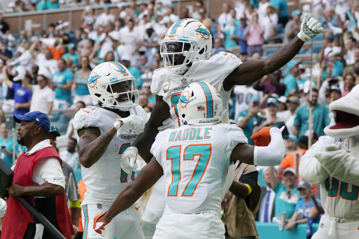 Miami Dolphins wide receiver Tyreek Hill (10), center, is congratulated by his teammates after scoring a touchdown during the second half of an NFL football game against the Cleveland Browns, Sunday, Nov. 13, 2022, in Miami Gardens, Fla. (AP Photo/Wilfredo Lee )
