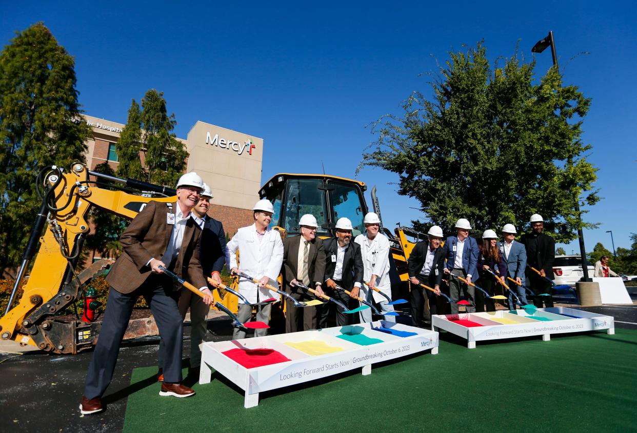 Mercy clinical staff and management lift shovels full of colored sand during a groundbreaking for Mercy's new south side emergency department on Friday, Oct. 6, 2023.