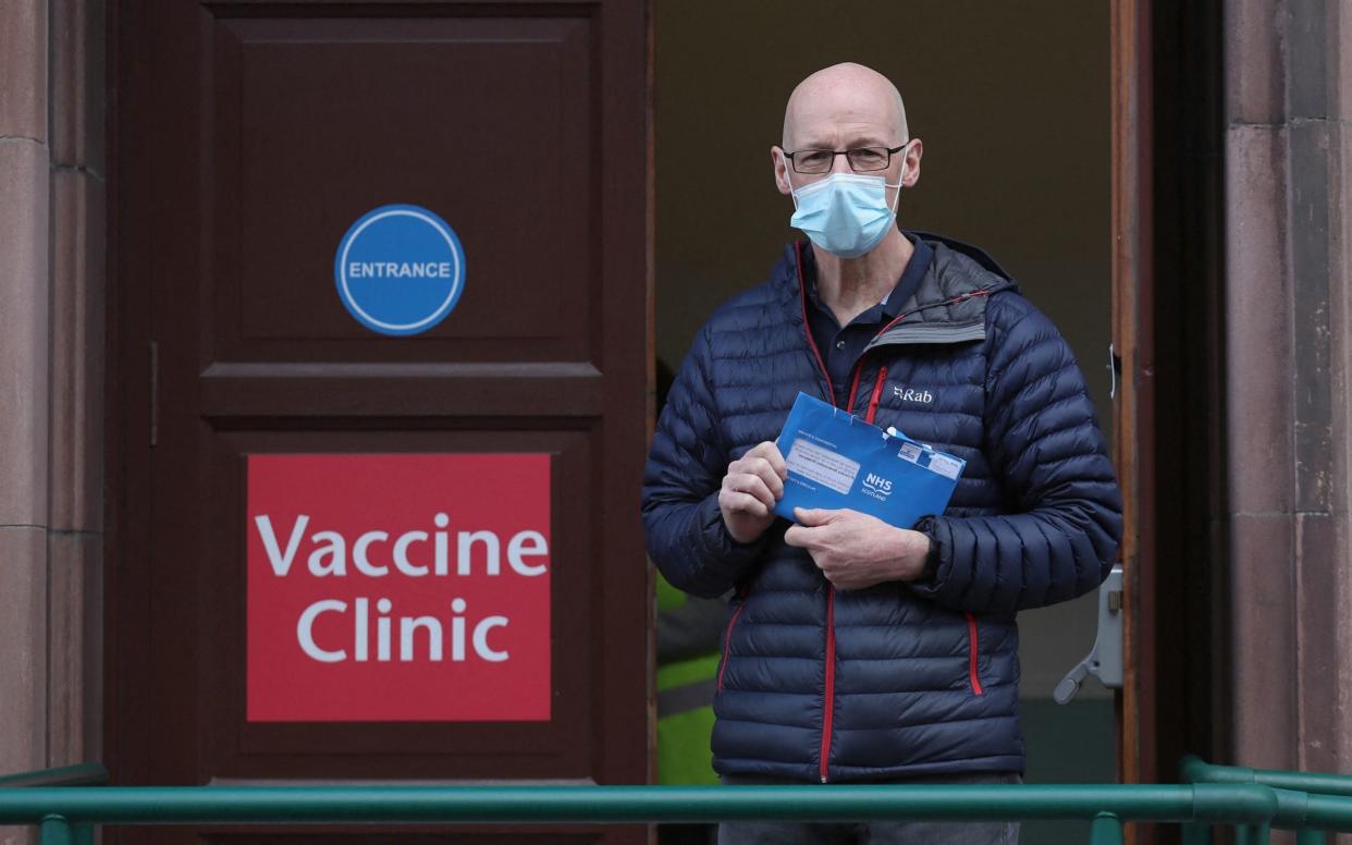 John Swinney arrives at the Vaccine Clinic holding his blue envelope  - ANDREW MILLIGAN/AFP