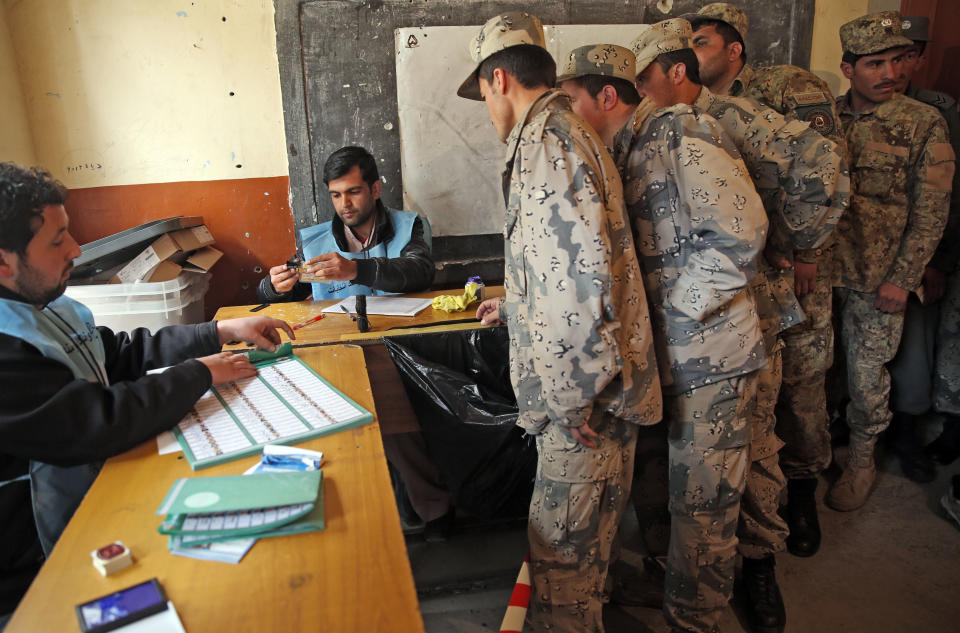 Afghan security personnel line up for registration process before they cast their votes at a polling station in Kabul, Afghanistan, Saturday, April 5, 2014. Afghans flocked to polling stations nationwide on Saturday, defying a threat of violence by the Taliban to cast ballots in what promises to be the nation's first democratic transfer of power. (AP Photo/Massoud Hossaini)