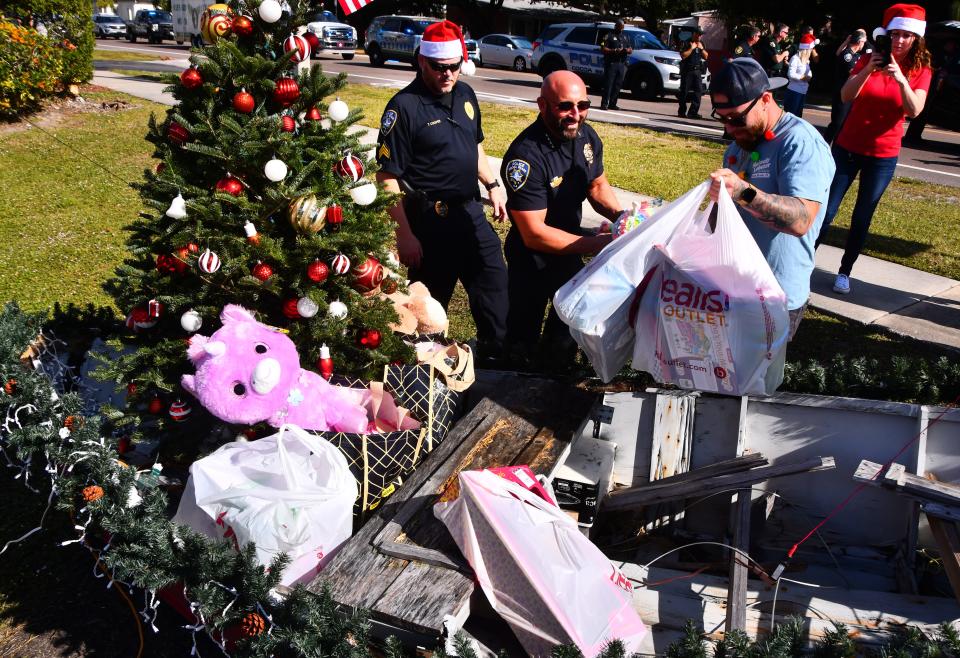 Cocoa Beach Police Chief Scott Rosenfeld (in middle) helps fill a boatload of toys during the December 2021 Reverse Christmas Parade.