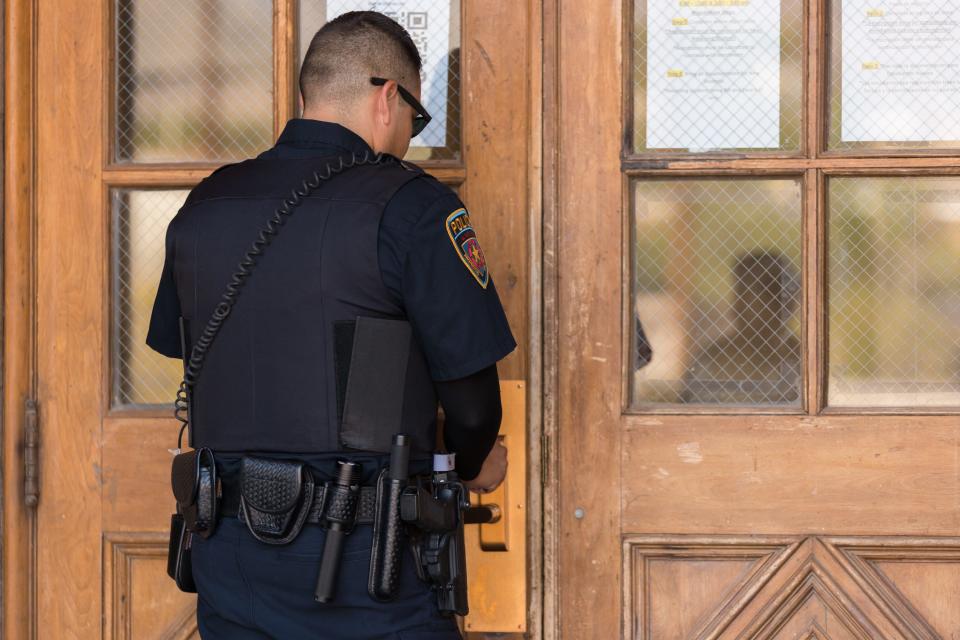 El Paso Independent School District Officer Sergio Delgado checks a campus door to make sure it is locked on Thursday morning, Aug. 11, 2022, at Austin High School in El Paso, Texas