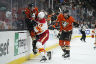 Calgary Flames' Nikita Zadorov (16) checks Anaheim Ducks' Jakob Silfverberg (33) as Ducks' Isac Lundestrom (21) watches during the second period of an NHL hockey game Friday, Dec. 3, 2021, in Anaheim, Calif. (AP Photo/Jae C. Hong)