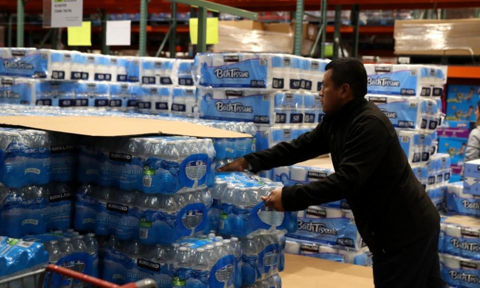 A customer grabs a case of drinking water at a Costco store on 14 March 2020 in Novato, California.