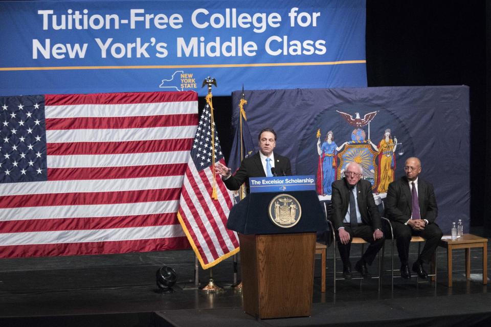 FILE- In this Jan. 3, 2017 file photo, New York Gov. Andrew Cuomo, left, is joined by Vermont Sen. Bernie Sanders, center, and Chairperson of the Board of Trustees of The City University of New York William C. Thompson, as he speaks during an event at LaGuardia Community College in New York. Cuomo recently wrapped up a series of speeches around the state detailing a 2017 agenda that includes free college tuition, an expanded child care tax credit and a "buy American" plan giving domestic companies preference in state purchases. (AP Photo/Mary Altaffer, File)